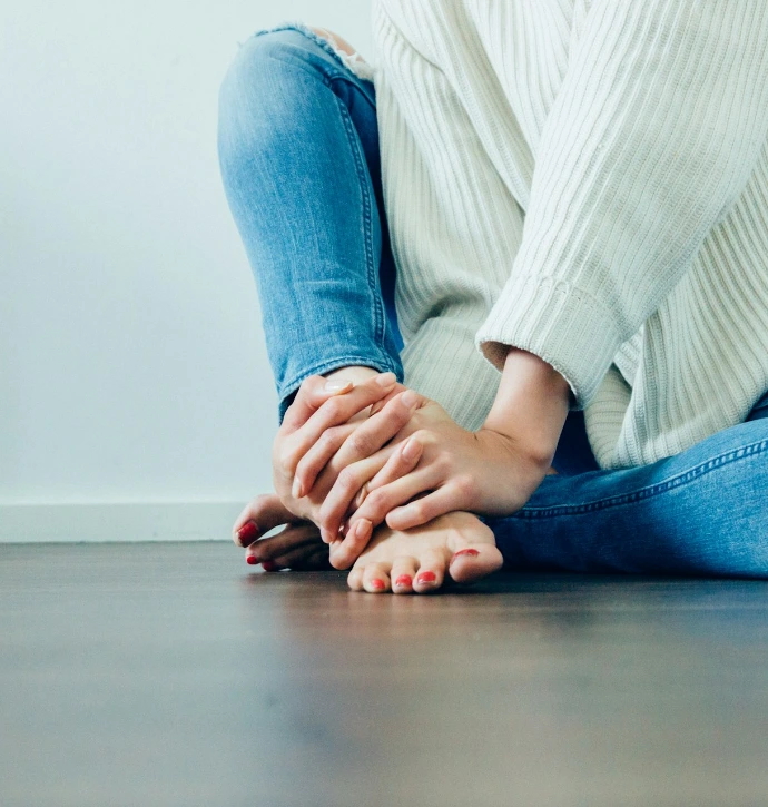 person wearing distressed blue denim jeans inside room