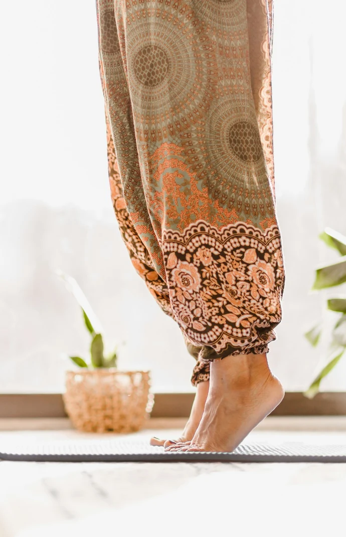 person in brown and beige floral skirt standing on white table